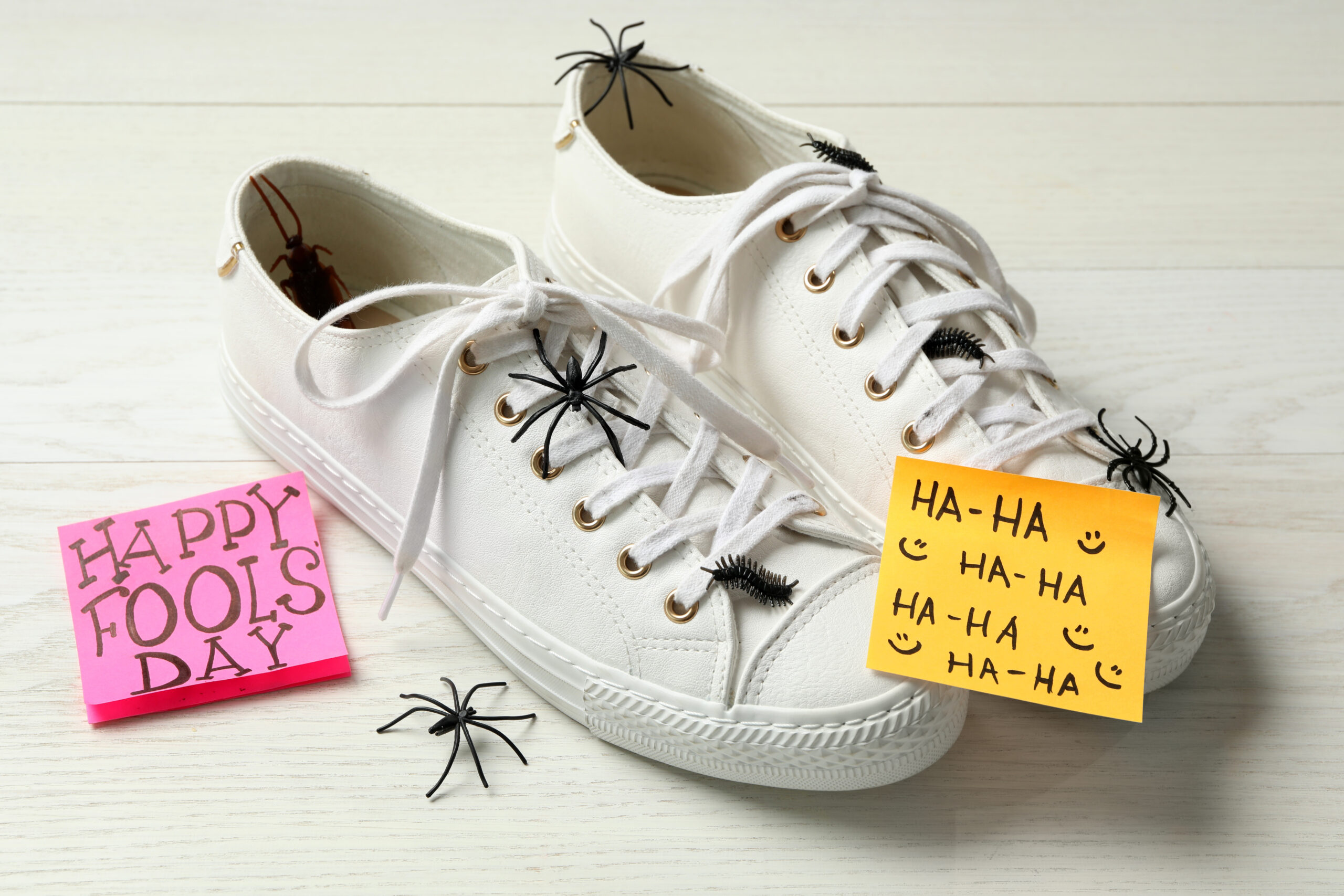 A pair of sneakers covered in fake spiders with notes saying happy fools’ day and ha ha