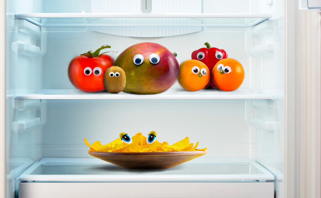 open refrigerator containing food with googly eyes on it