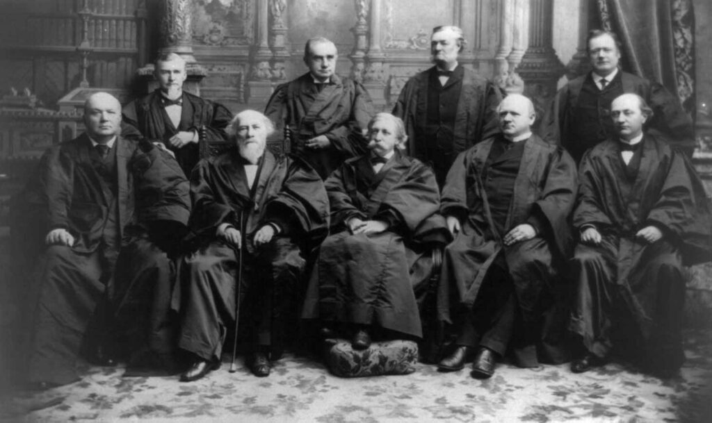 Black and white photo of the 1894 Supreme Court, nine white men sitting together in black robes