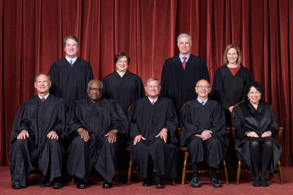 Justices Samuel A. Alito, Clarence Thomas, John G. Roberts, Stephen G. Breyer, Sonia Sotomayor, Brett M. Kavanaugh, Elena Kagan, Neil M. Gorsuch, and Amy Coney Barrett pose for a photo in black robes.