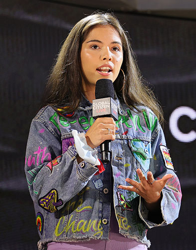 A young woman speaks into a microphone.