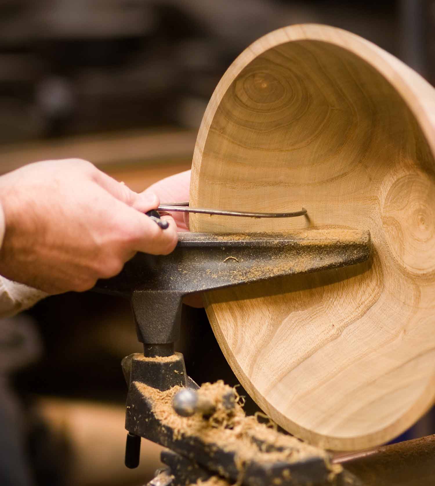 A tool is used to carve a wooden bowl.