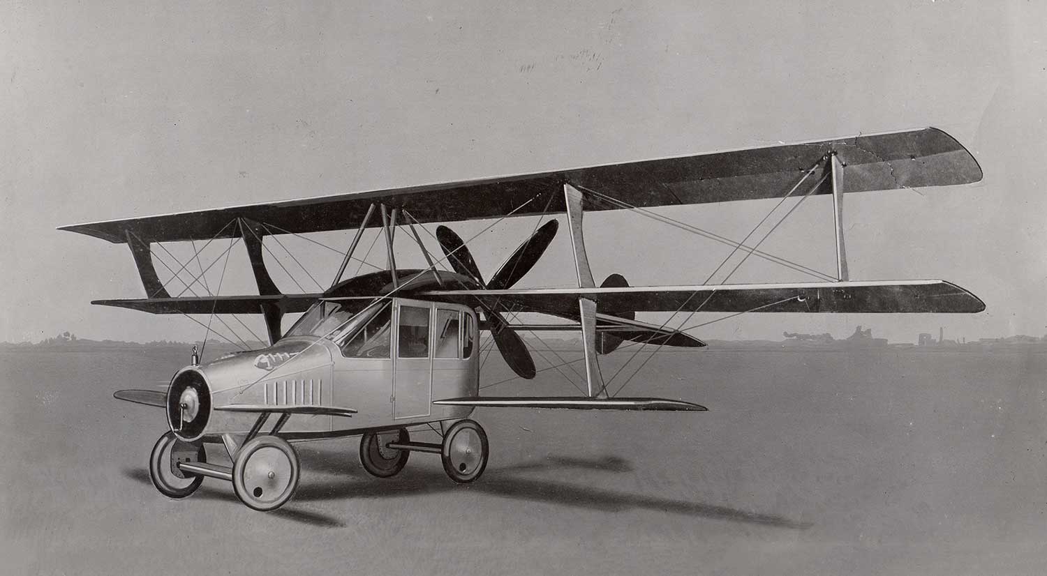 Black and white photo of a vehicle with both wings and four wheels
