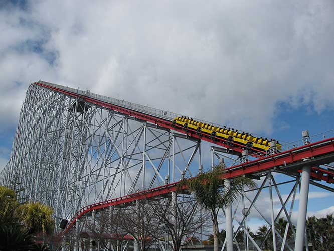 A roller coaster moves along a track as it approaches a peak
