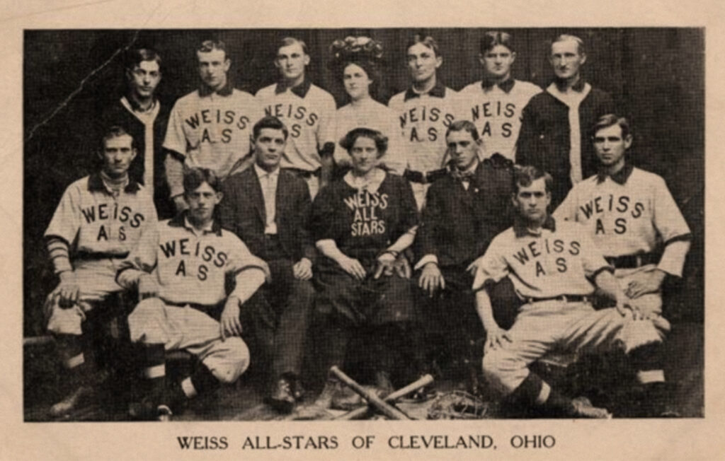 Black and white photo of a baseball team in uniforms reading Weiss AS. All players are male except Alta Weiss, in the center.
