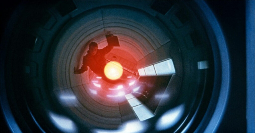 A man appears to be inside a circular lens with a red light framing him