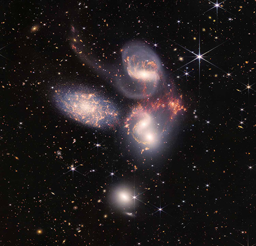 Four galaxies appear to be glowing and interacting in space