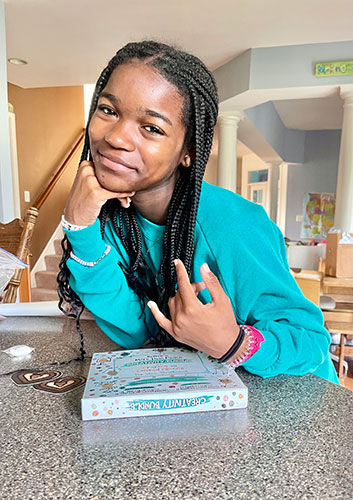 Bellen Woodard sits at a counter in a home and smiles for the camera.