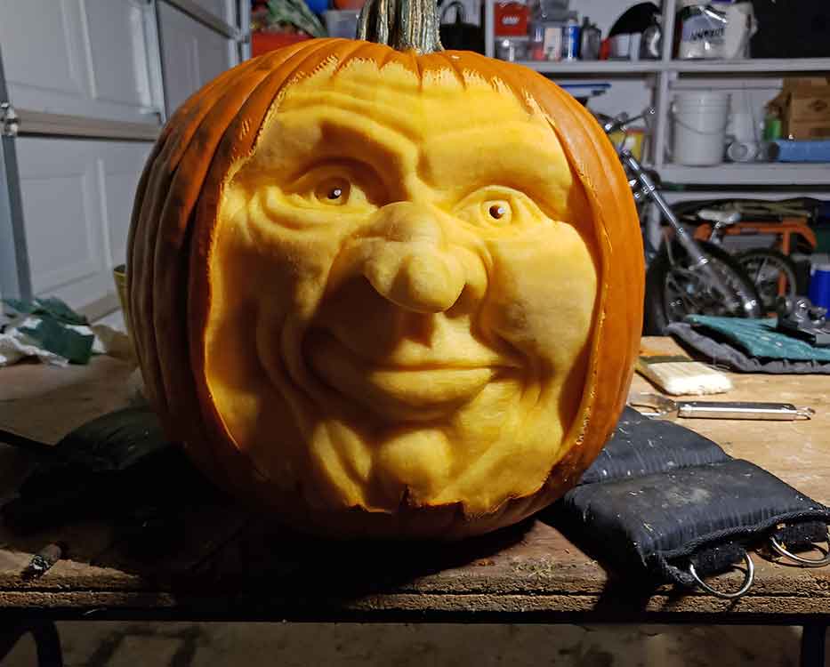 A smiling face carved into the side of a pumpkin.