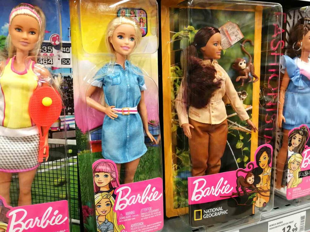 Closeup of four Barbie dolls in packages on display at a store