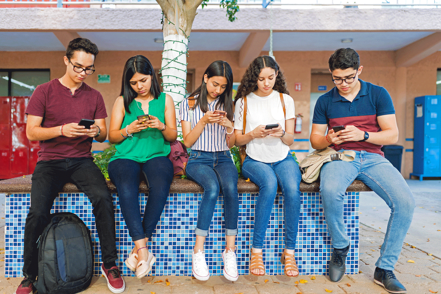 Animation of five students sitting on a ledge on their phones with text bubbles of their conversation appearing.