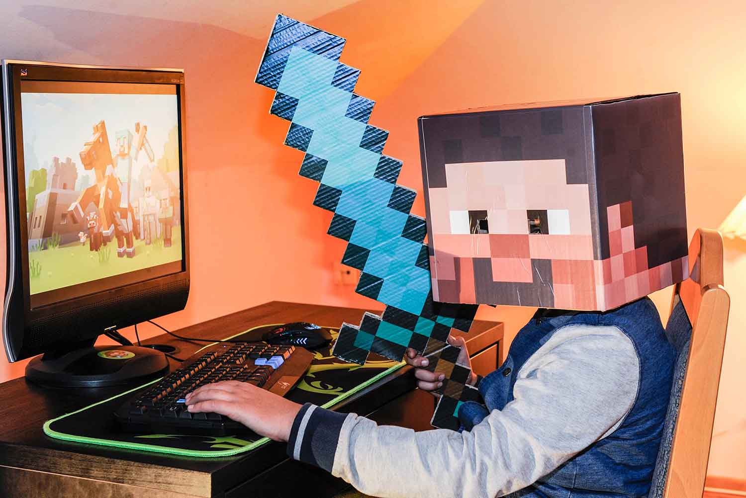 A Minecraft kid sits at a computer playing Minecraft.
