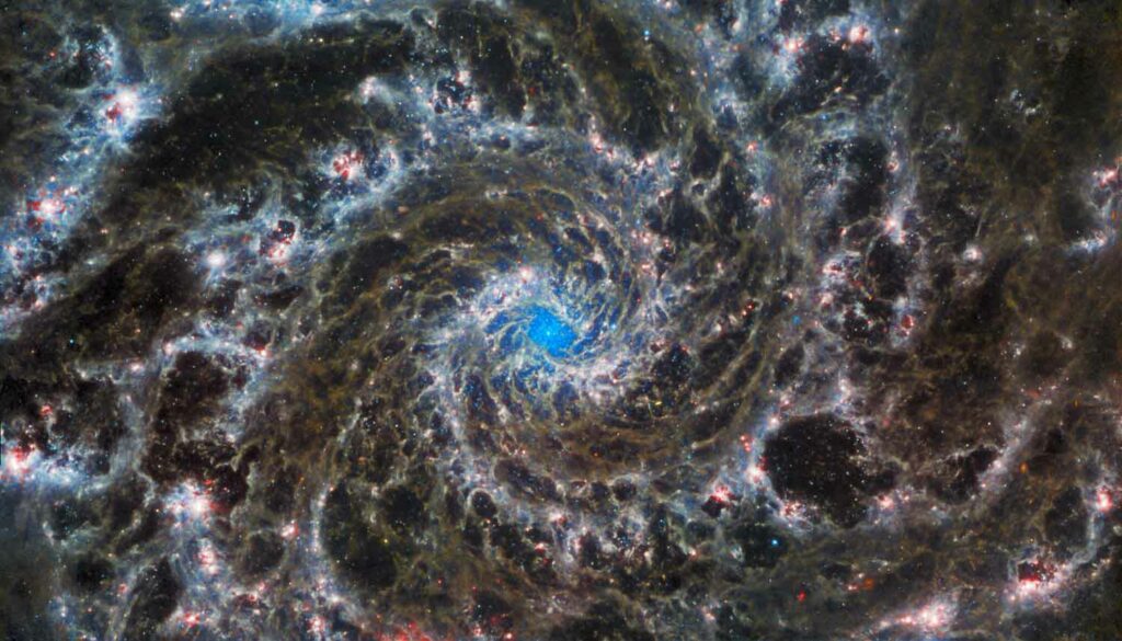 A galaxy with a blue center and swirling gases all around.