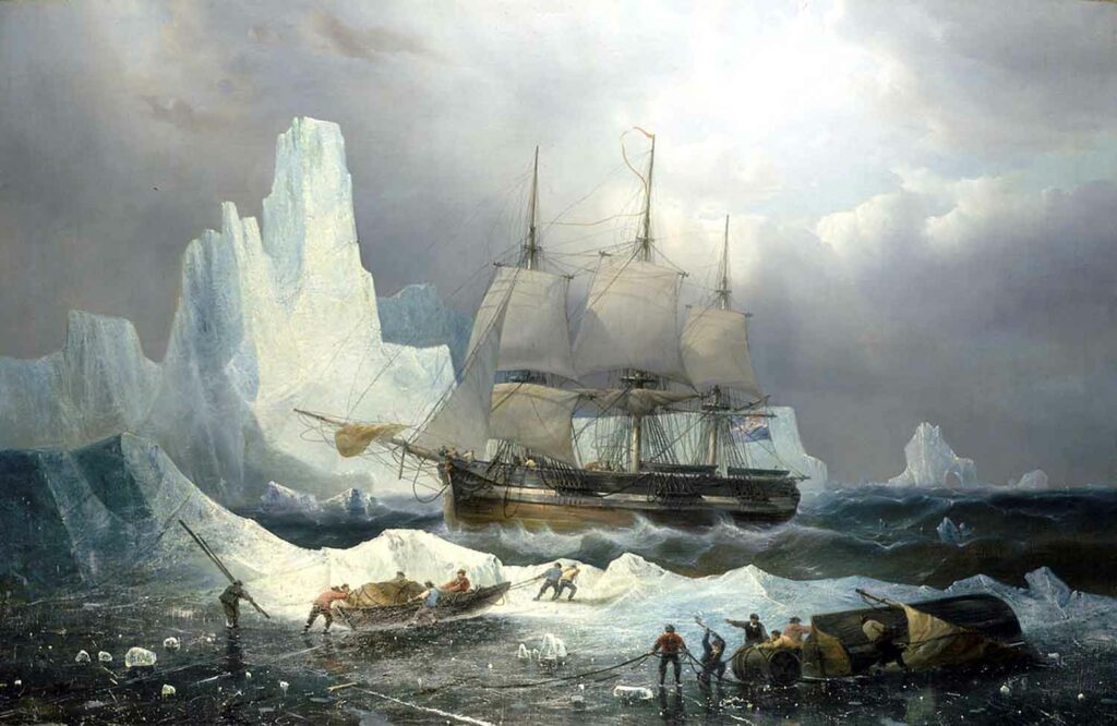 Crewmembers haul a small boat as a sailboat sits in the background stuck between two icebergs.