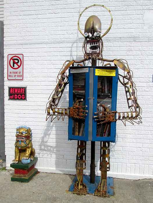 A metal figure with a head, legs, and arms, and books inside its torso