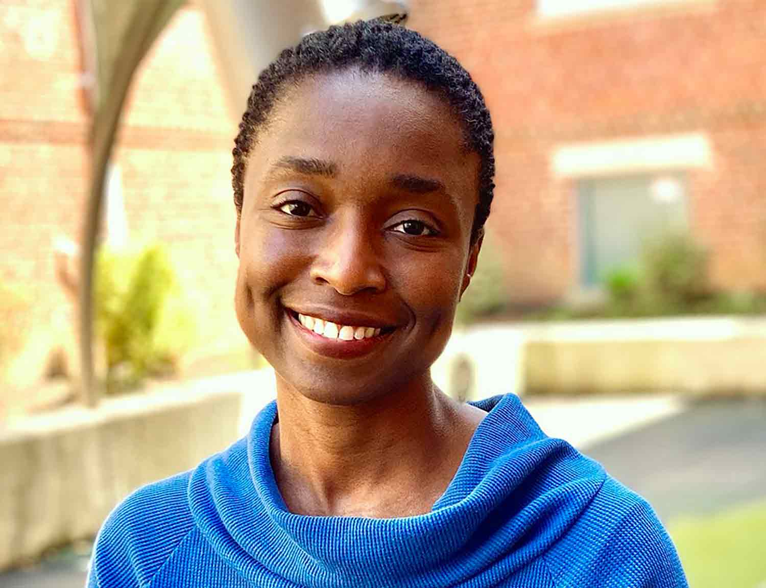 Headshot of a woman smiling with a building in the background