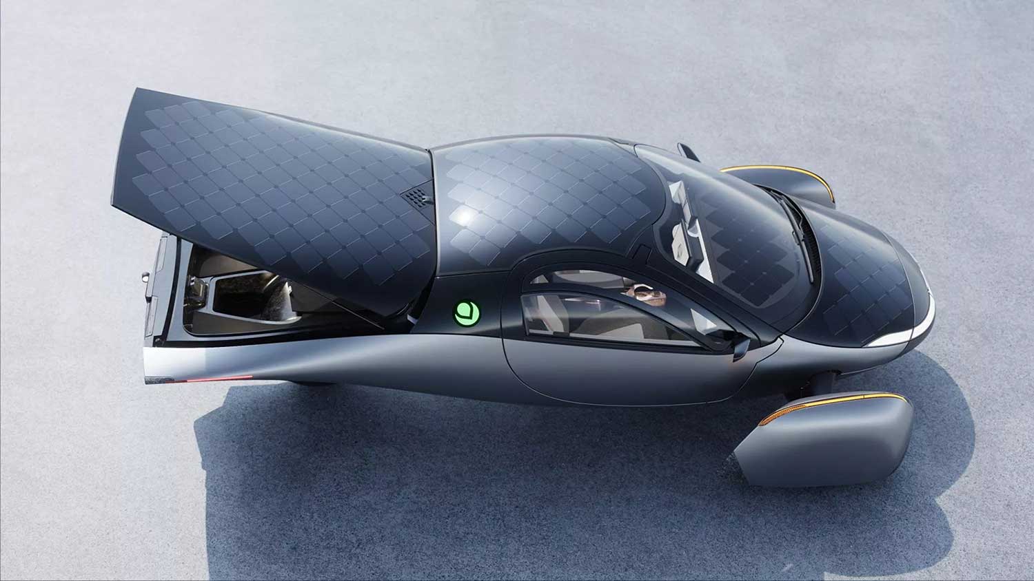 three-wheeled black and silver car see from above with solar panels on the roof