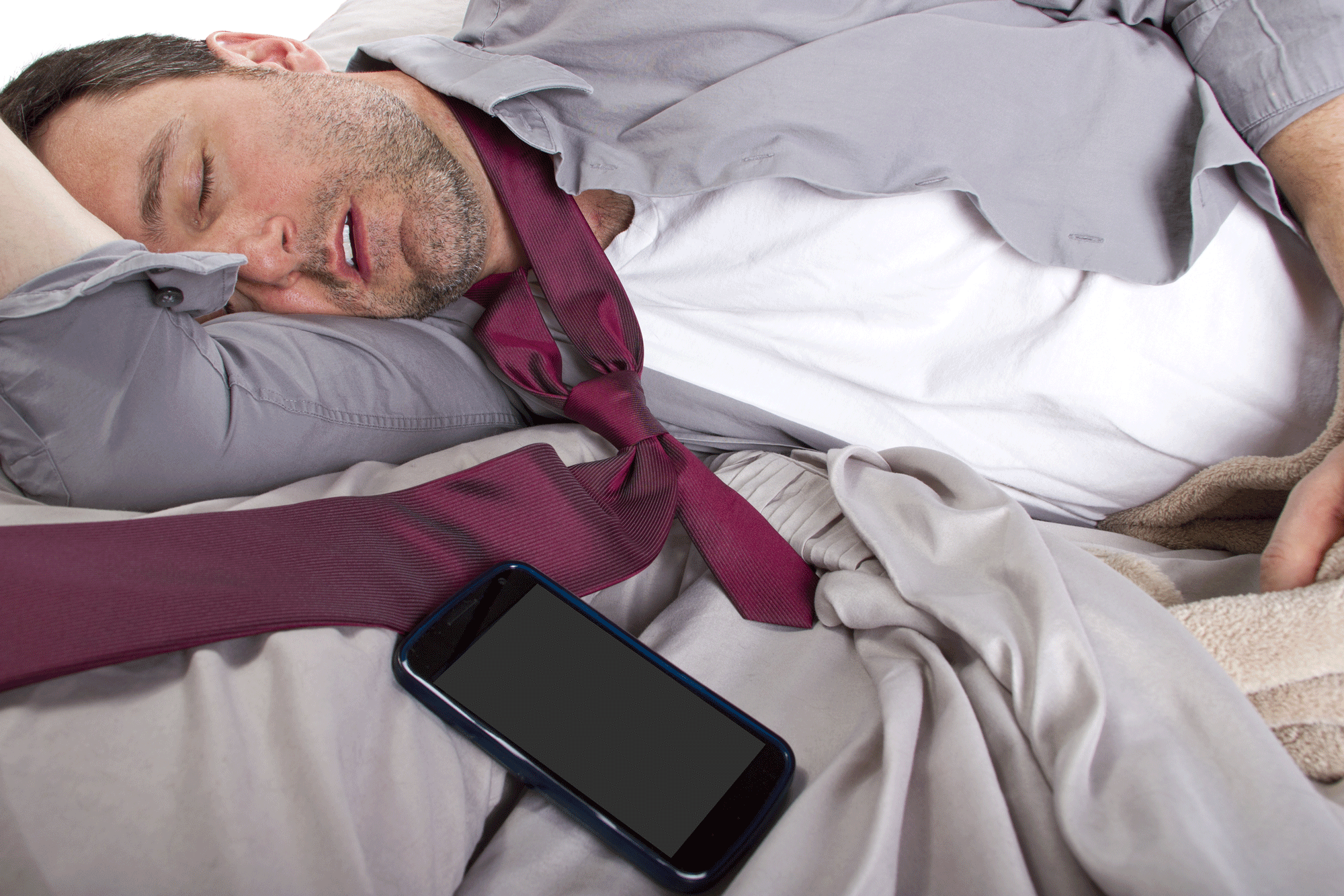 A man in an open shirt and loosened tie sleeps as his phone gives an alert that Friday is part of the weekend.