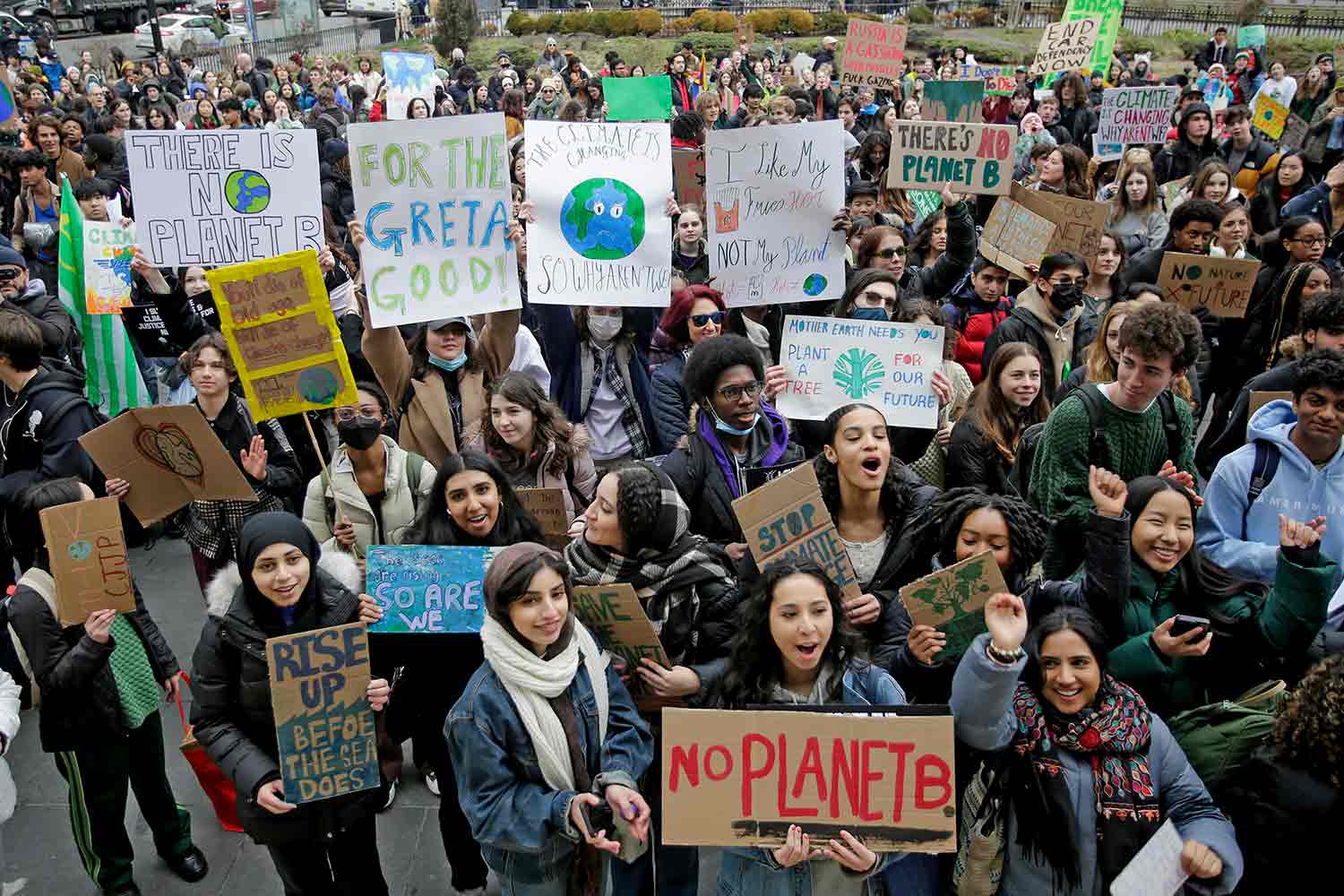 A crowd of young people with many holding up signs protest for action to stop climate change.