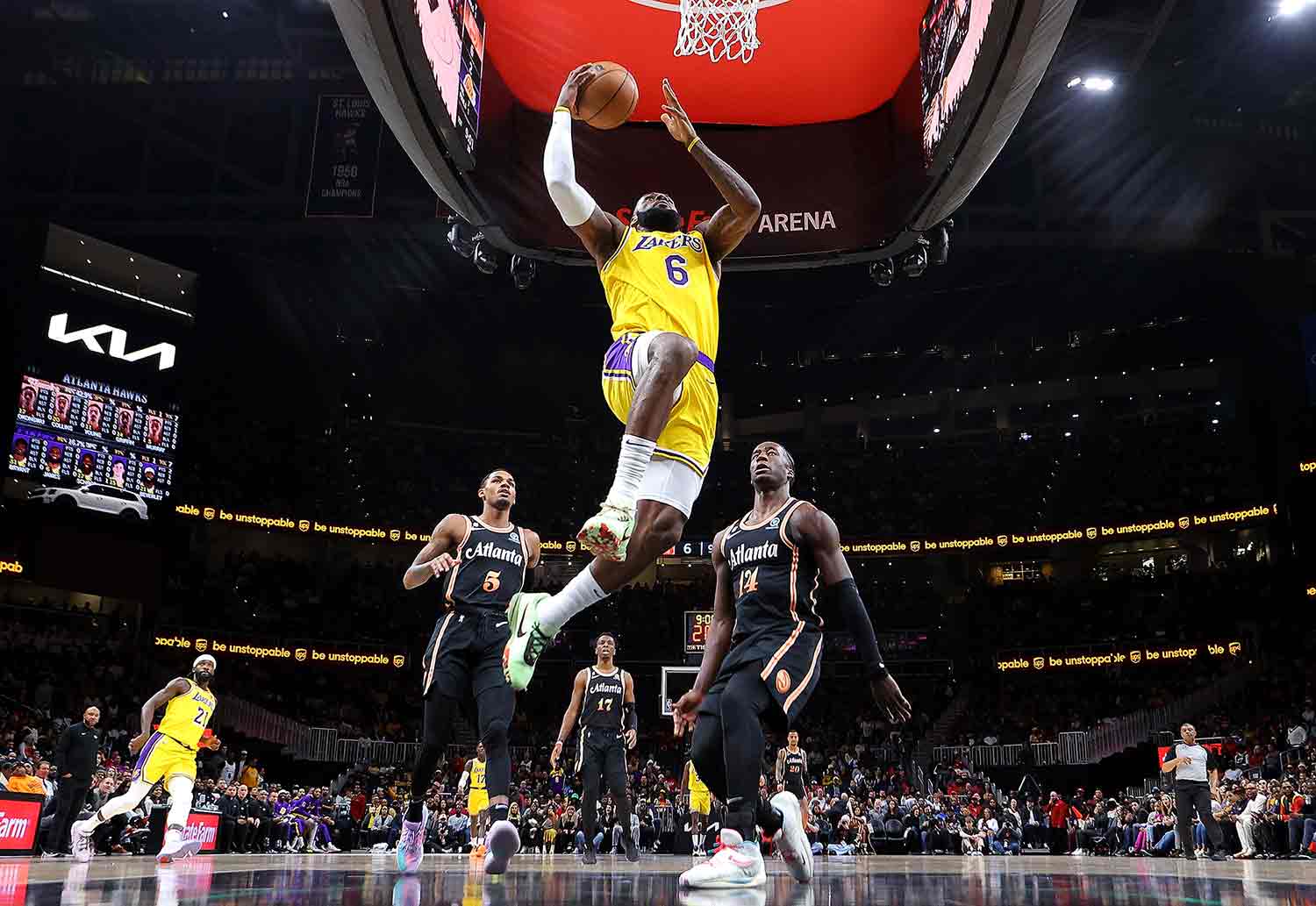 LeBron James hovers in the air about to make a basket as two opponents look on behind him.