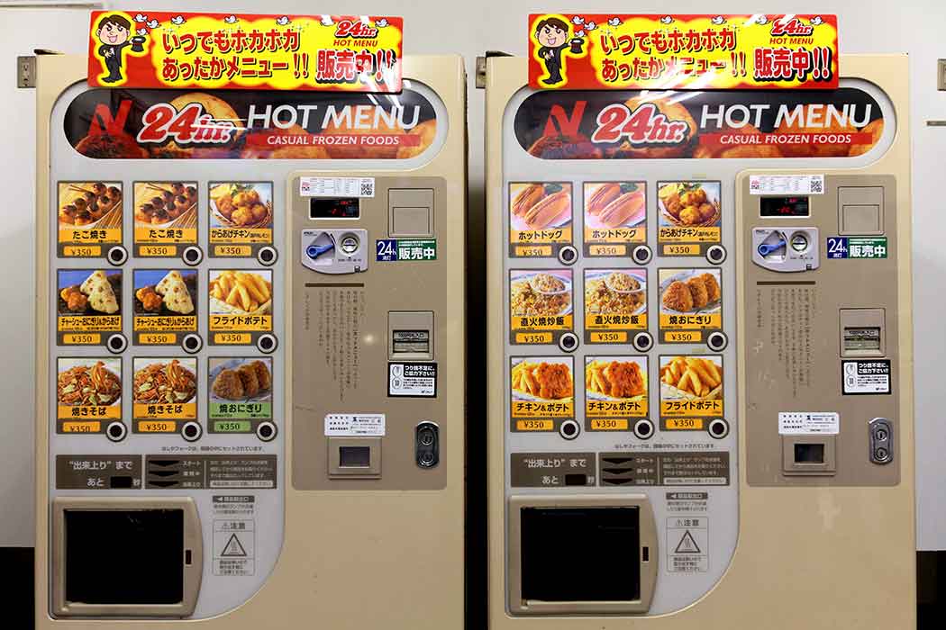 Two identical vending machines with different photos of hot foods shown next to each button.