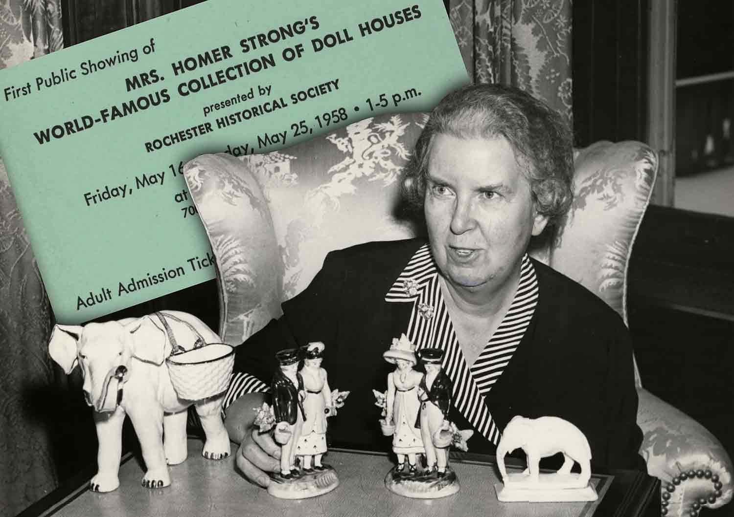 A woman sits in an armchair with figurines on a table in front of her and a card reading Mas. Homer Strong’s World Famous Collection of Dollhouses behind her.