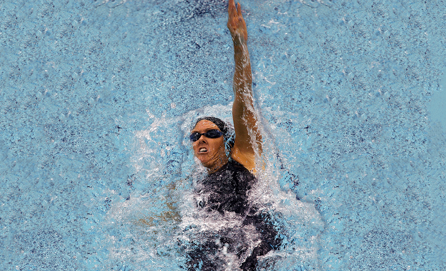 Trischa Zorn does the backstroke in a pool as 41 gold medals and some silver and bronze medals appear in the background one by one.