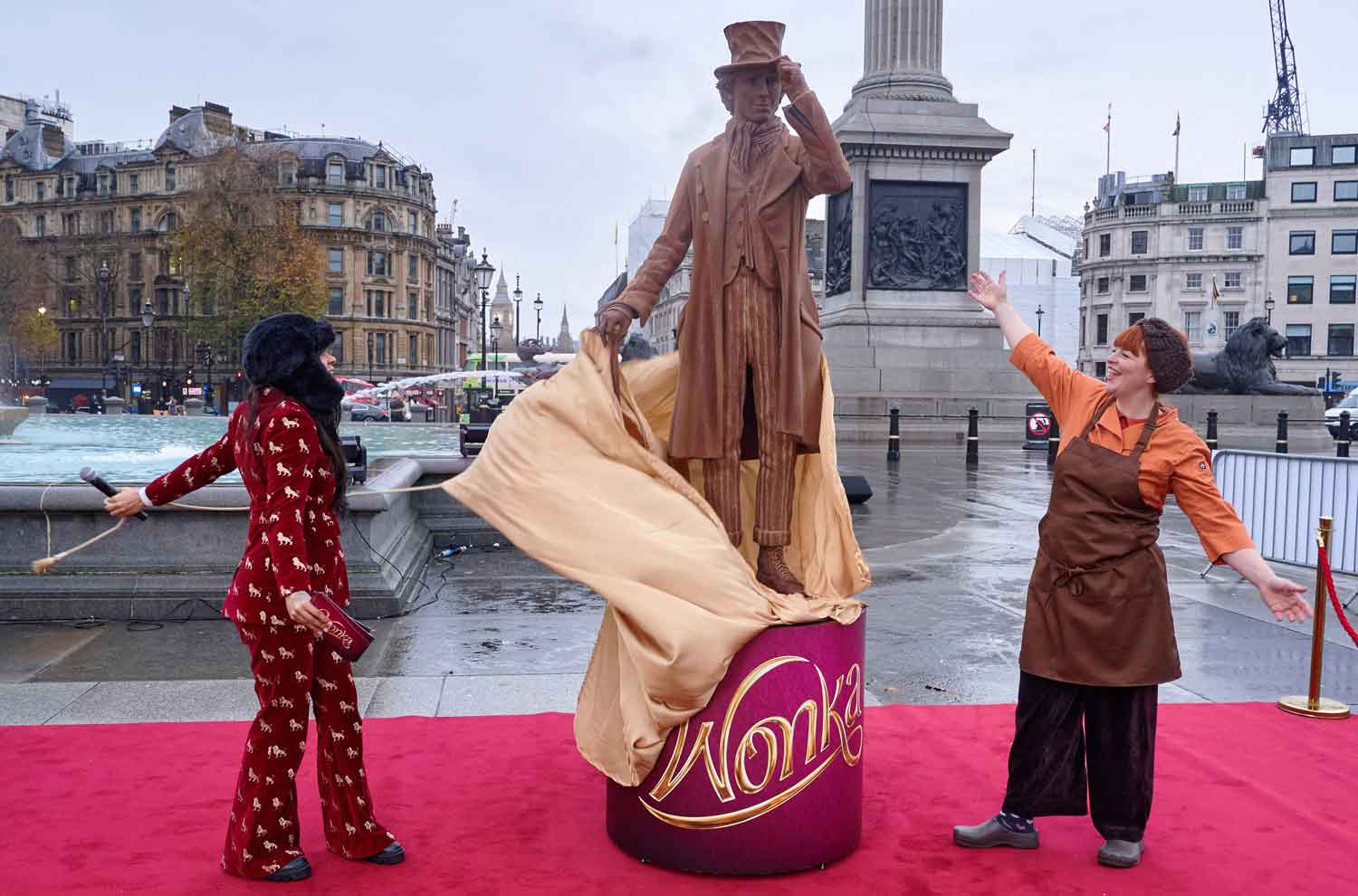 A woman with outstretched arms looks at a lifesize chocolate statue that has just been unveiled in Trafalgar Square.