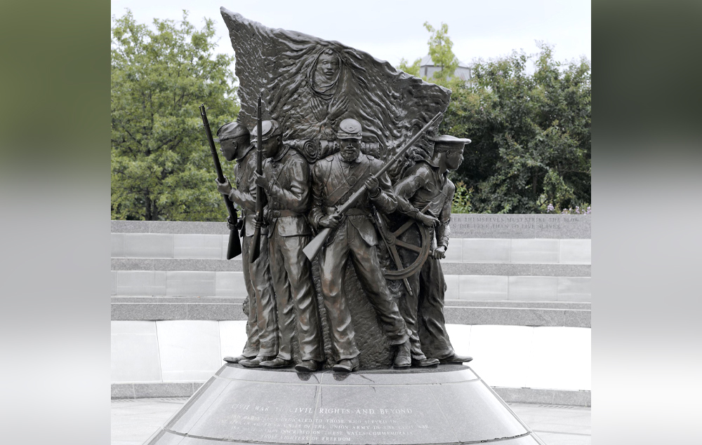 A bronze statue of Black soldiers and sailors in uniform and looking in many directions.