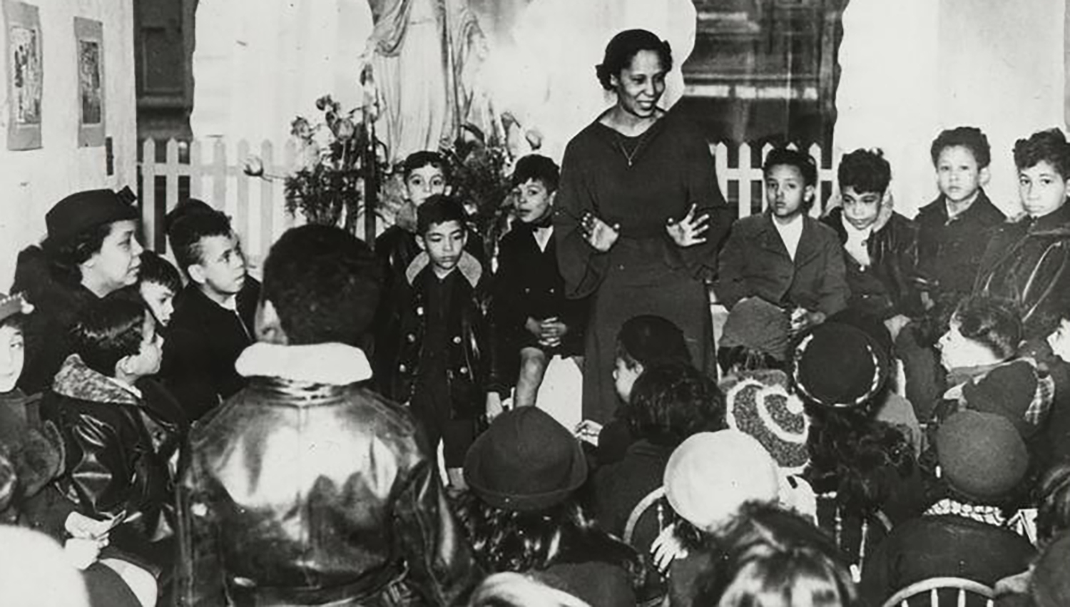 A young Pura Belpré speaks to a group of children.