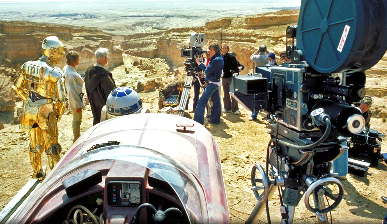 Behind the scenes of Star Wars IV, several characters stand in front of a camera at a remote canyon location.