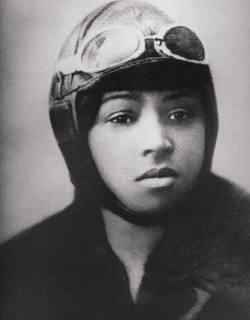Portrait of Bessie Coleman wearing a pilot helmet with goggles on her head.