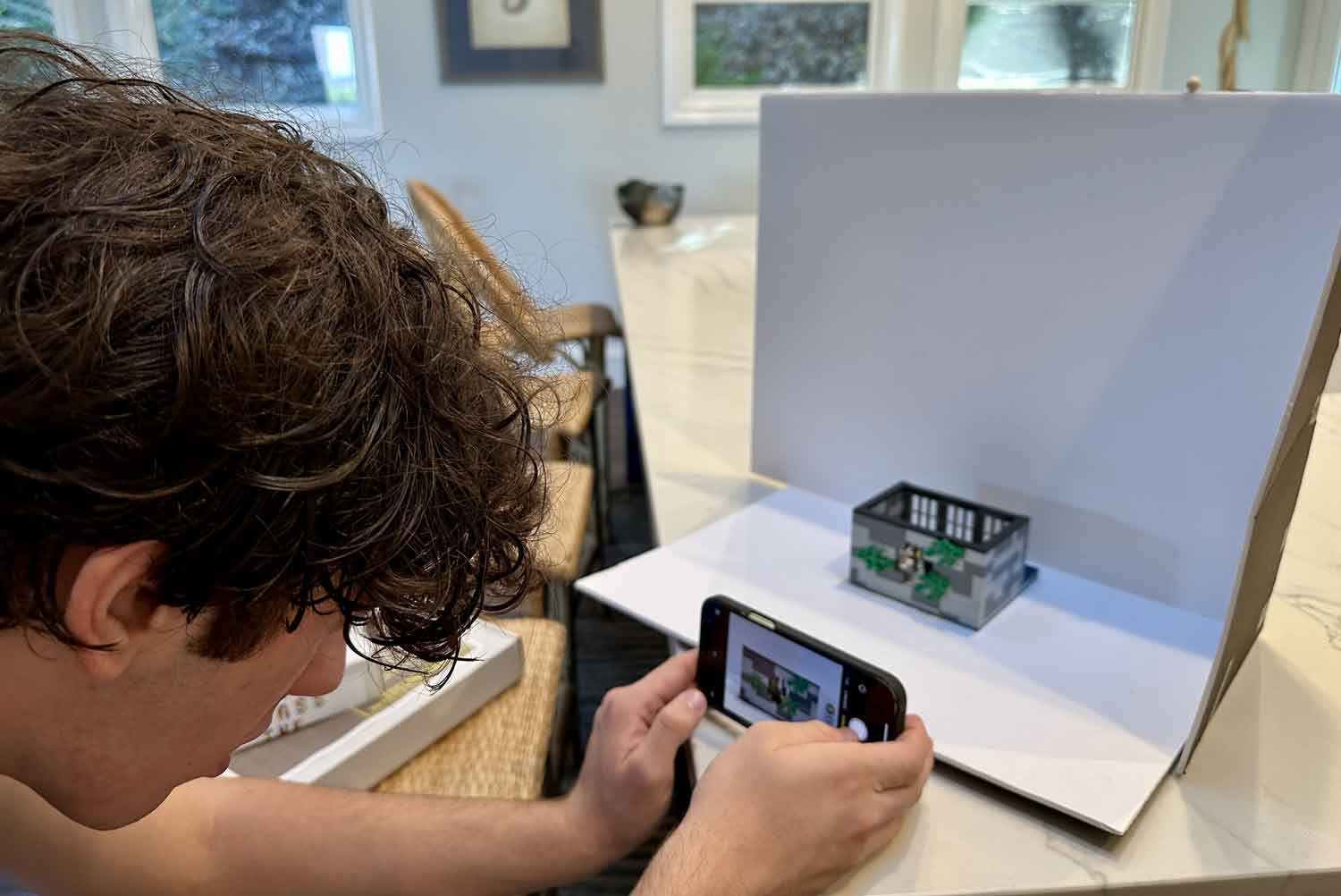A teen takes a photo of a constructed LEGO set.