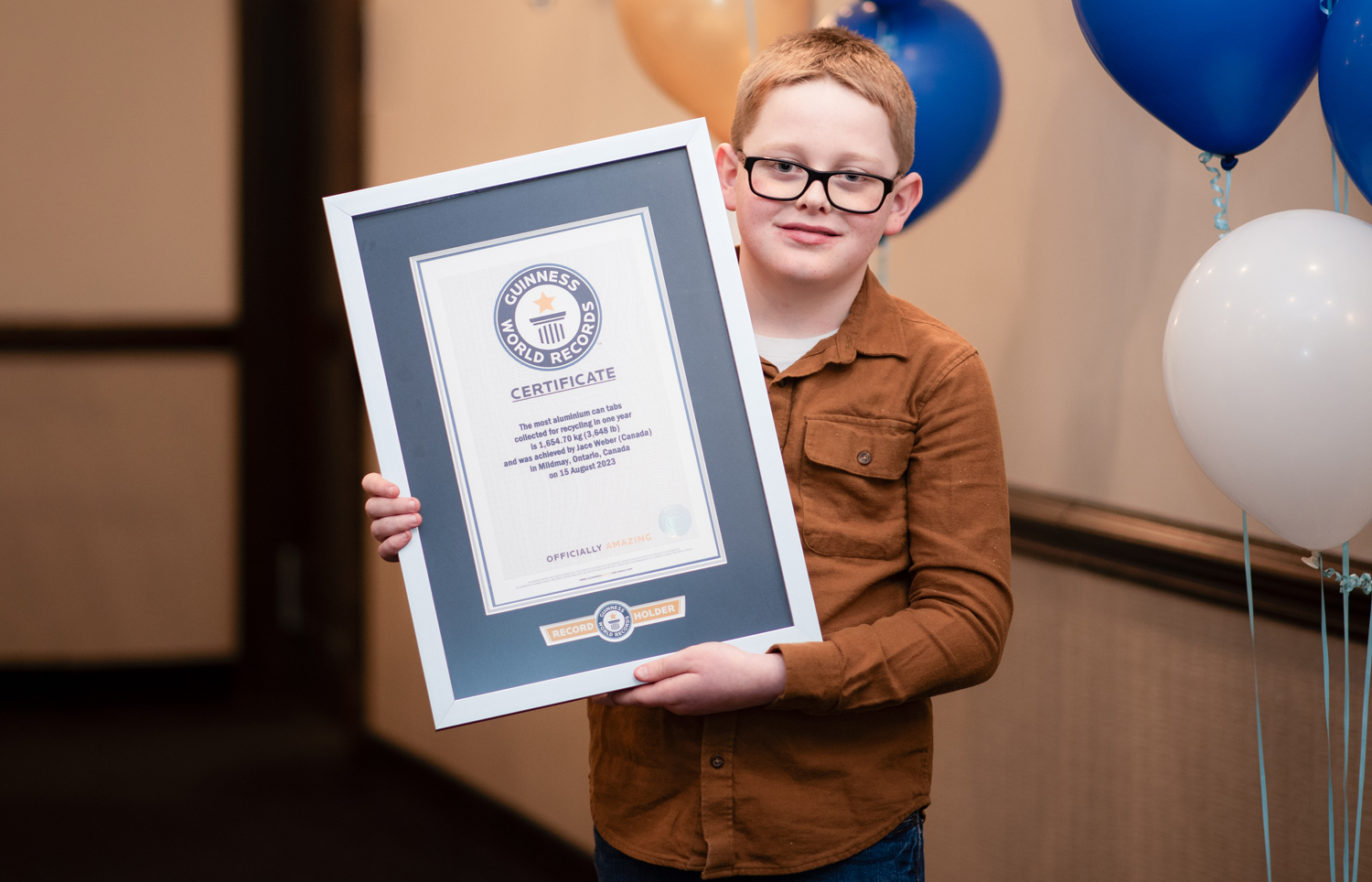 A 10-year-old child poses while holding a certificate from Guinness World Records.