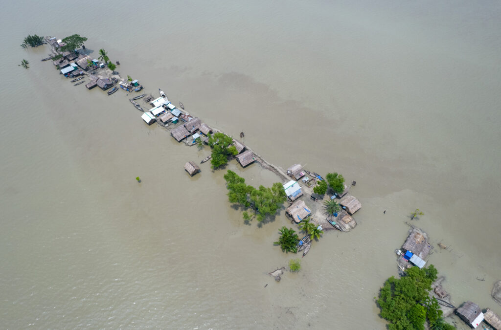 A heavily flooded village is seen aerially.