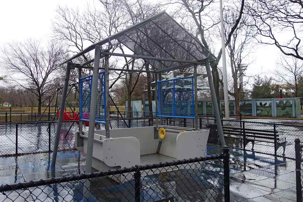 A wheelchair-accessible swing at an outdoor play area.