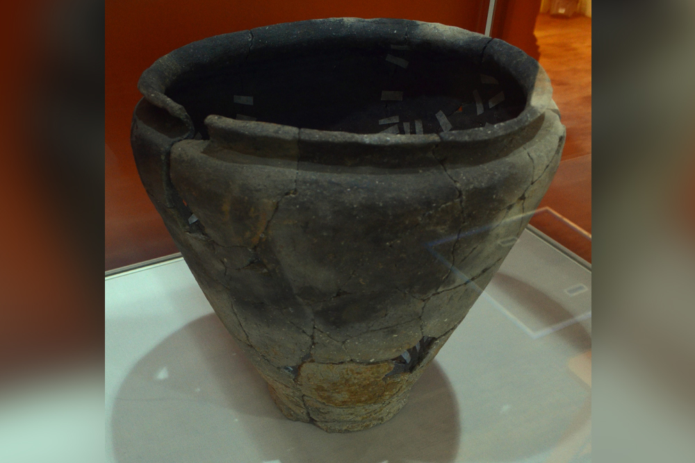 A large piece of pottery is in a display case.