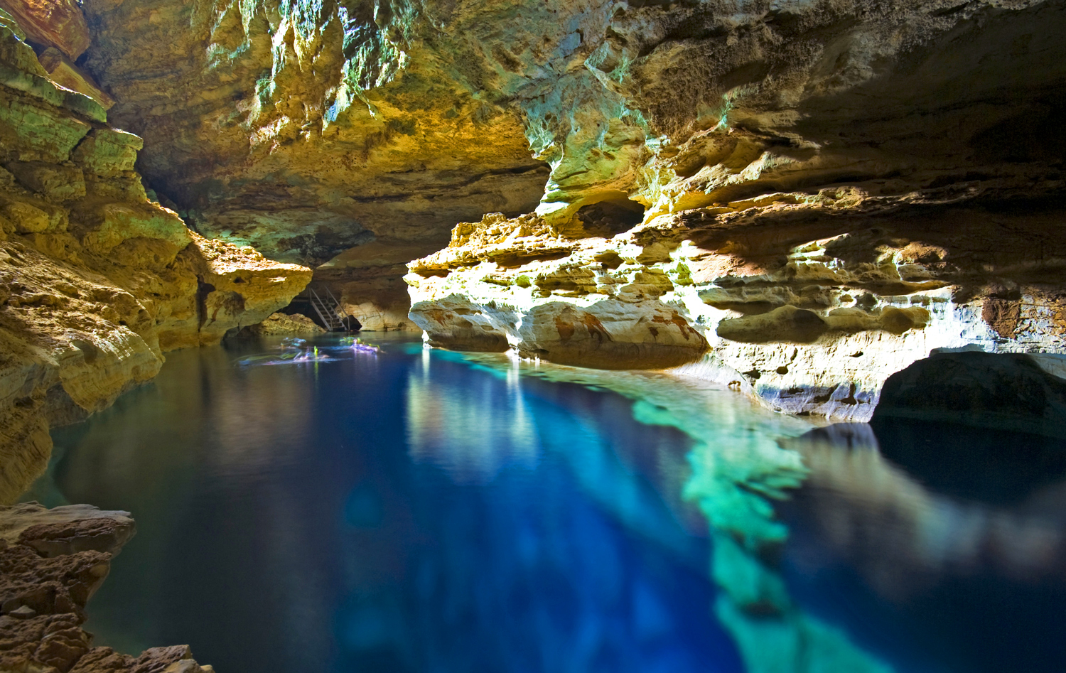 Limestone walls are reflected in a cave pool.