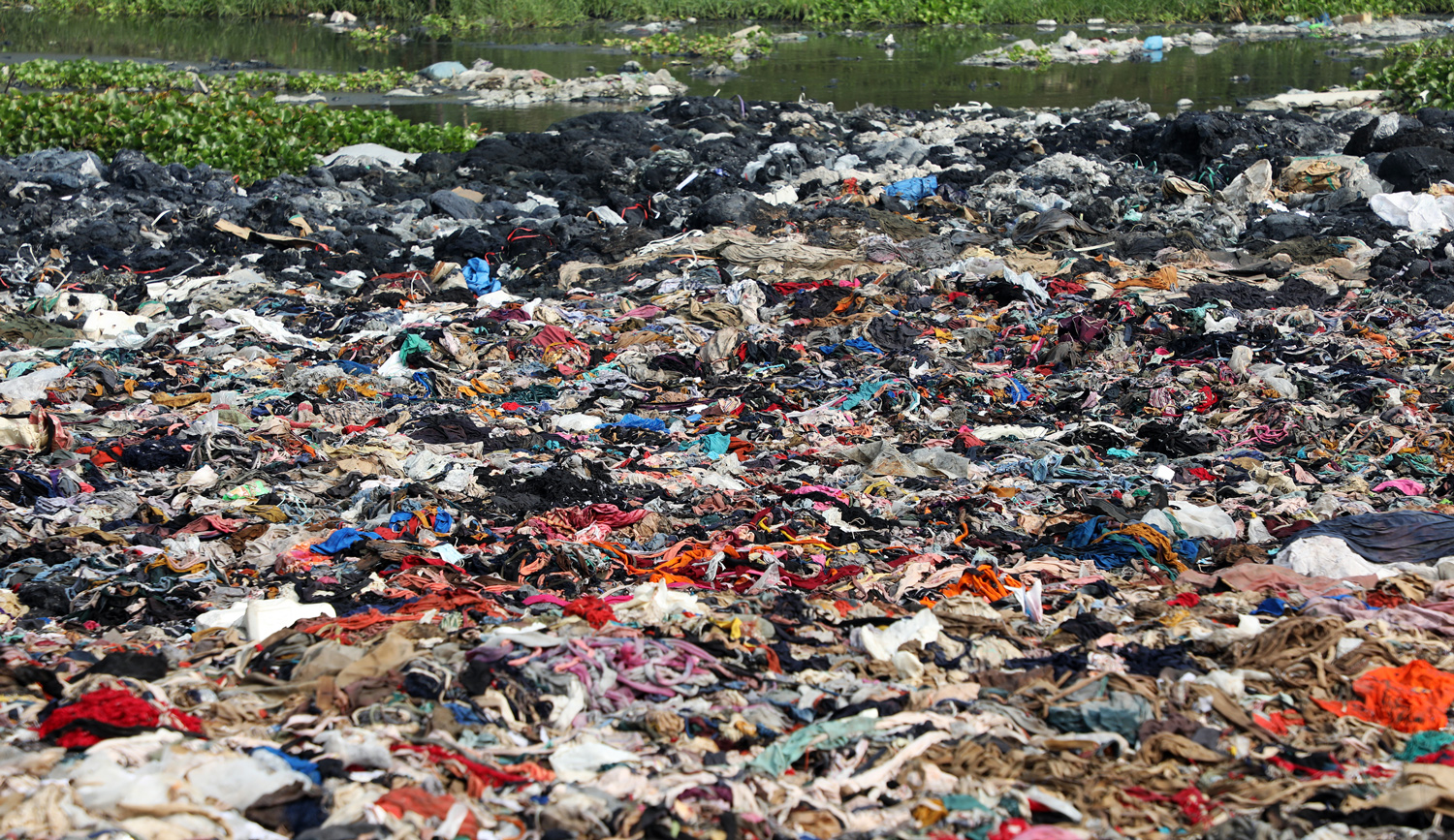 A large amount of textiles in many colors are scattered on land and in water.