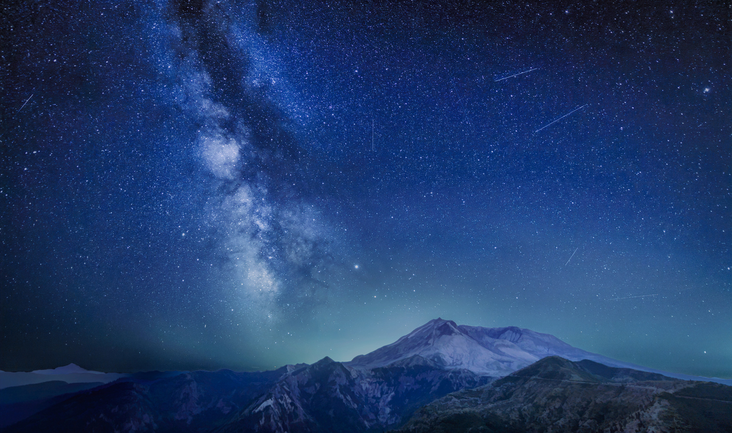 A meteor shower in a starry sky over snowy mountains.