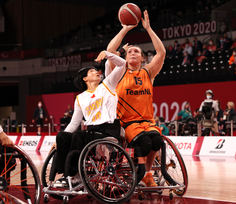 Mariska Beijer is poised to shoot a basket as another player tries to block her.