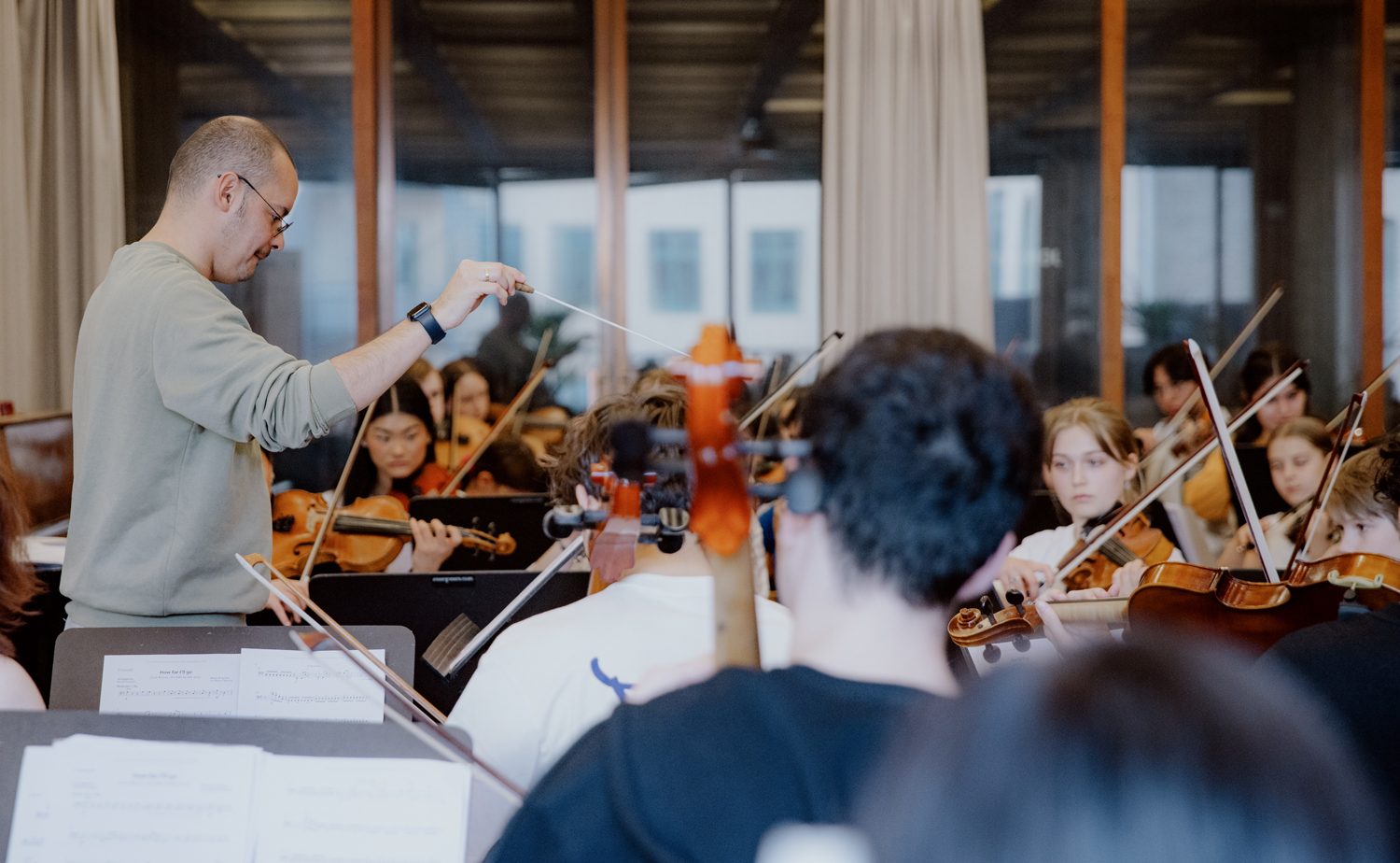 Ron Alvarez conducts as a group of musicians play music.