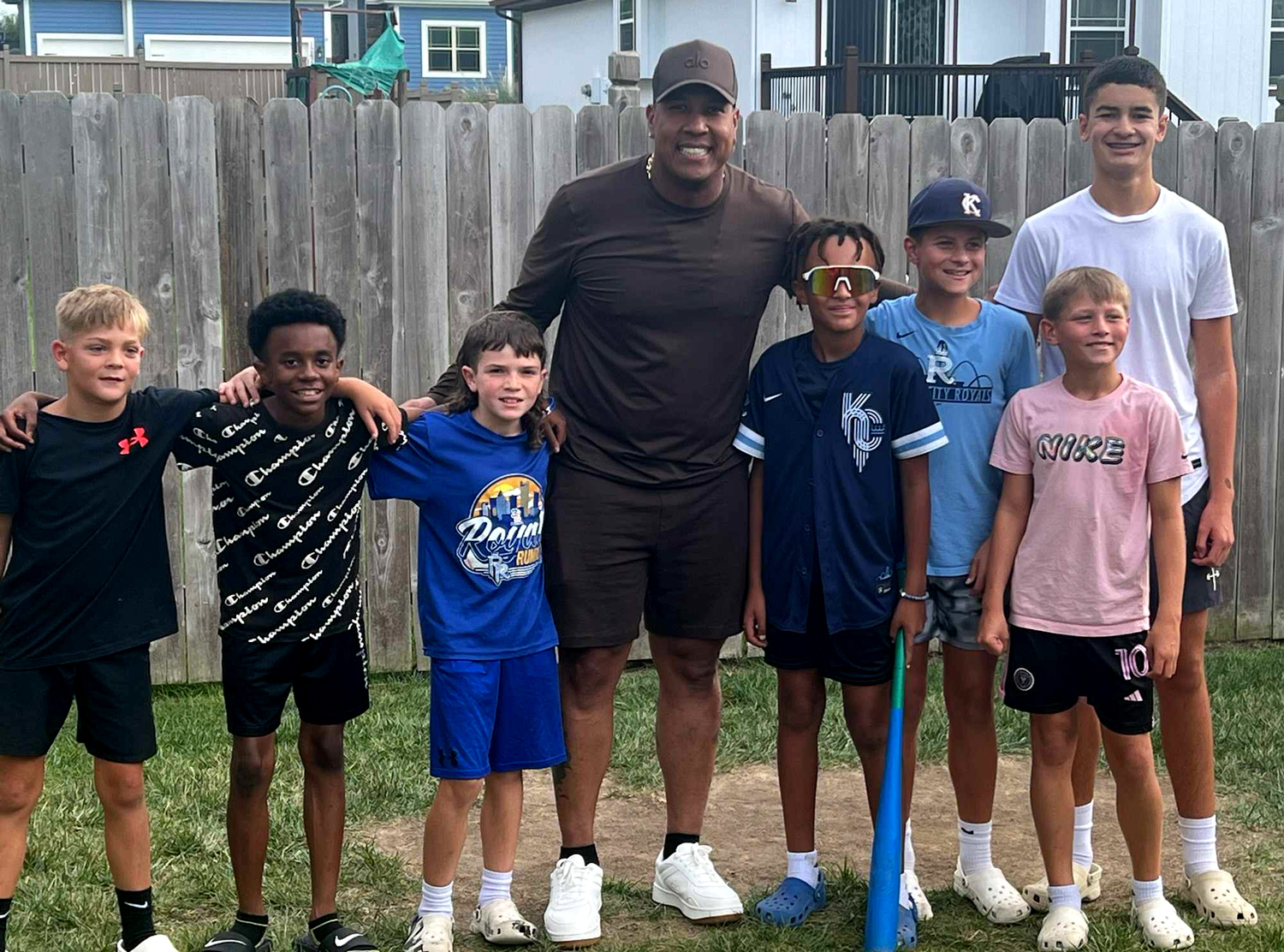 Salvador Perez poses in a backyard with seven children of different ages.