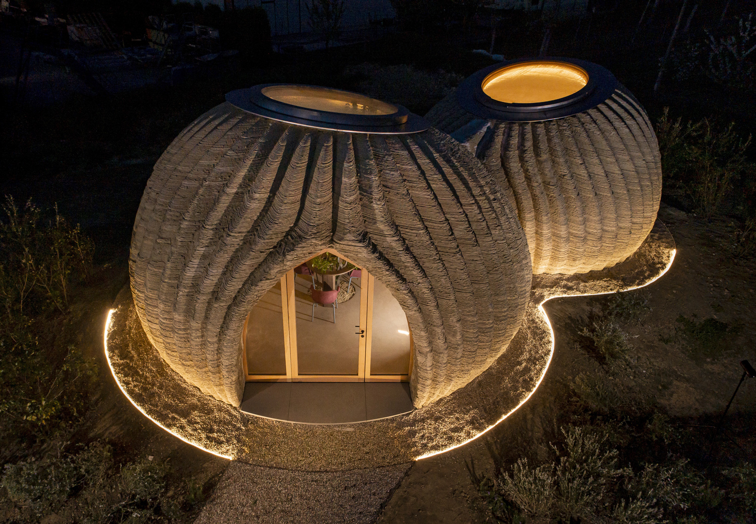 Overhead view of a home with two round sections at night.