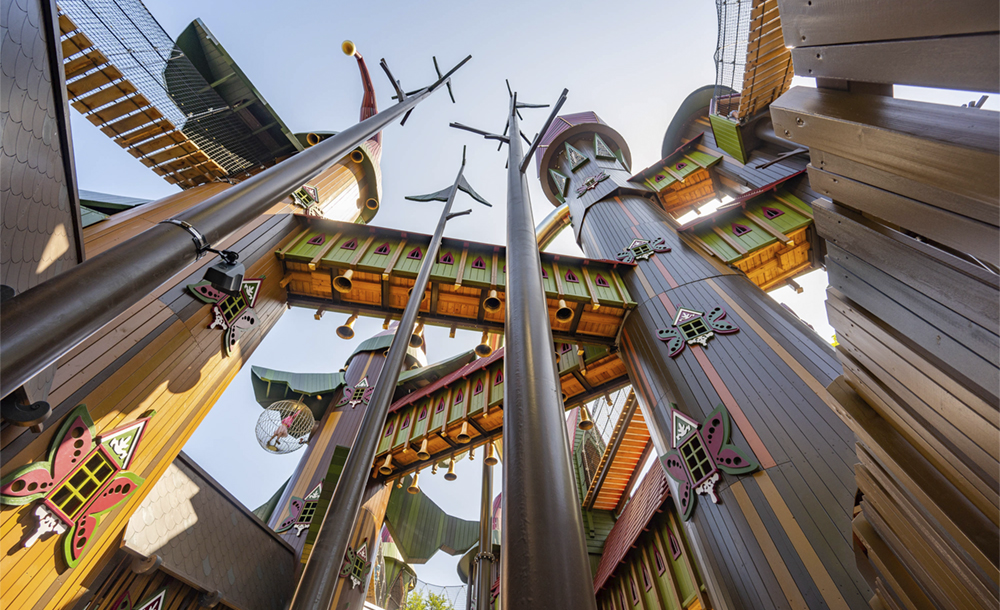 A large play structure with many turrets, bridges, and slides, as seen from below.