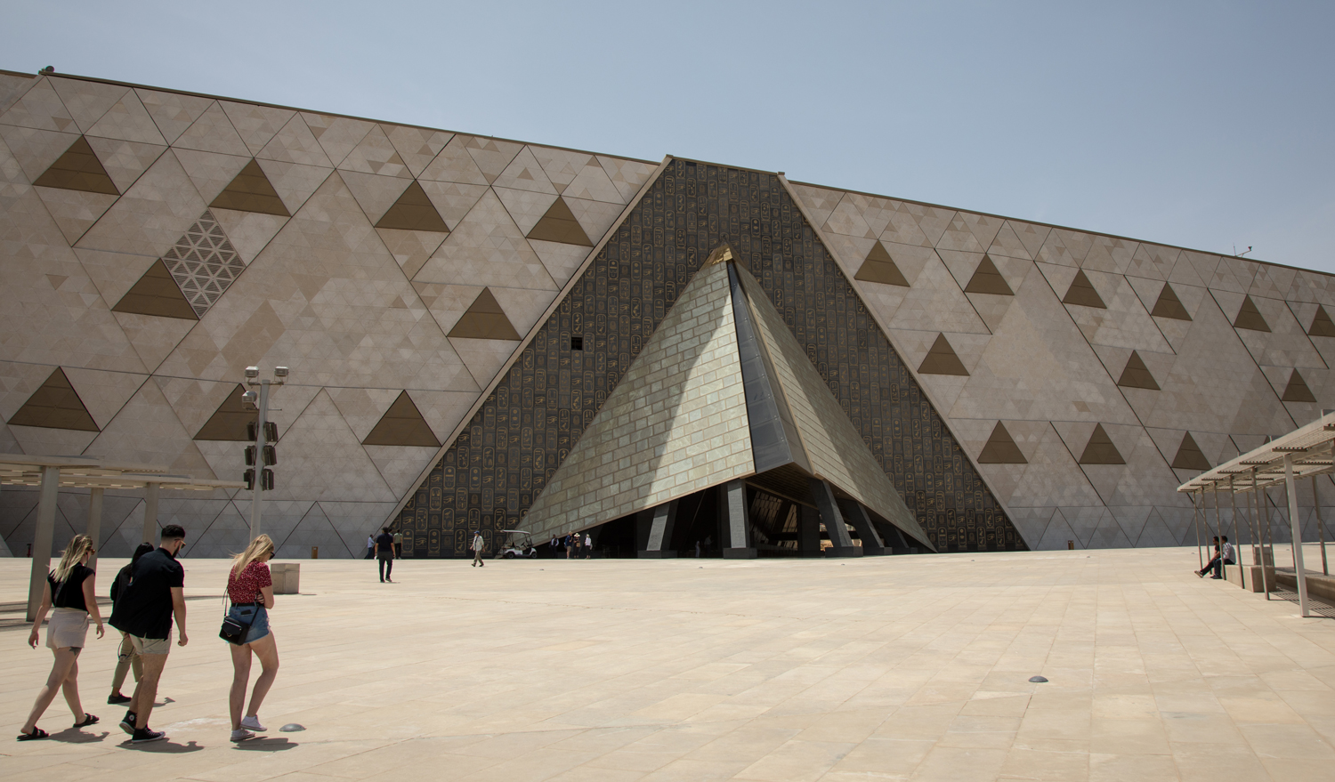 People walk on a plaza outside of the Grand Egyptian Museum.