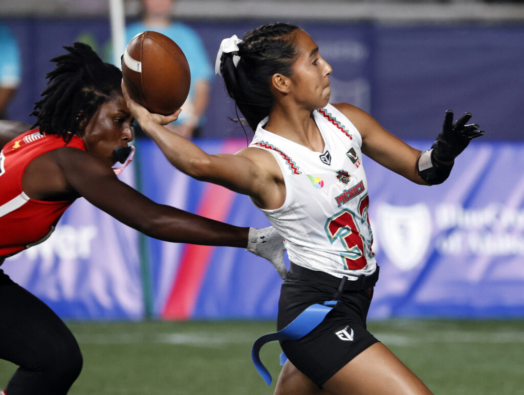 Diana Flores looks to throw a football as another player tries to take her flag.