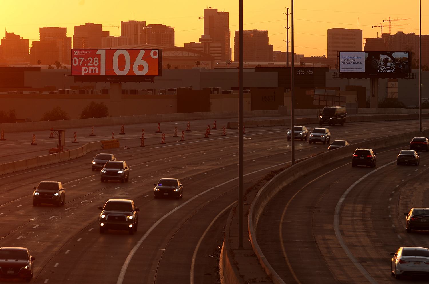 A billboard above a busy highway registers the temperature at 106 degrees Fahrenheit.