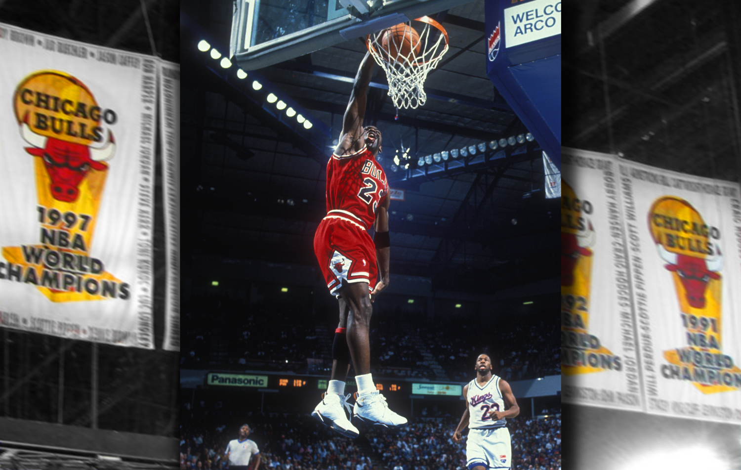 Michael Jordan soars above the floor to put the ball in the basket.