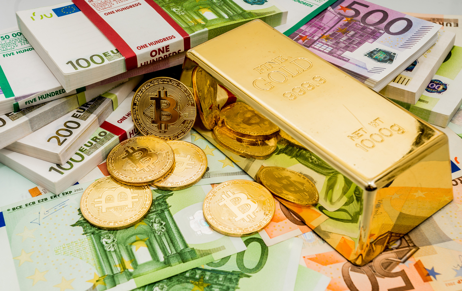 A collection of paper money, coins, and a gold bar.